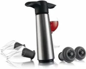 Stainless steel wine vacuum pump with rubber bottle stoppers and a pourer beside a glass of red wine