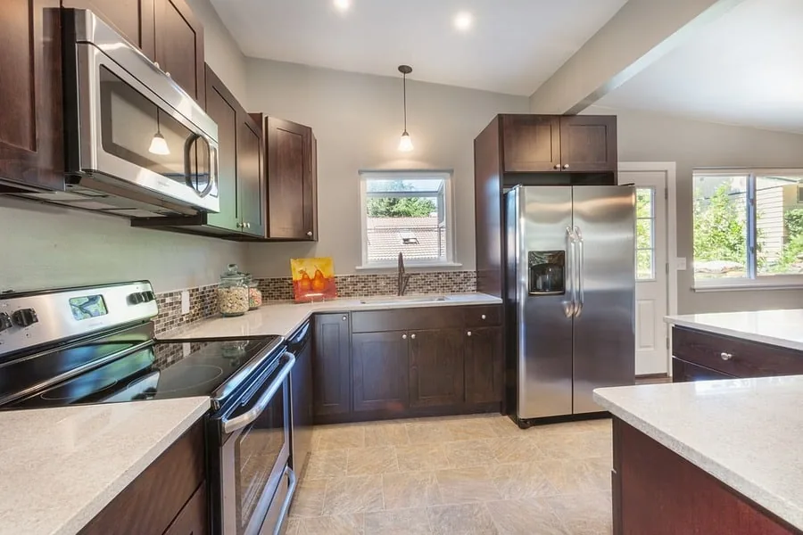 Modern kitchen with a stainless steel side by side refrigerator and dark wood cabinets