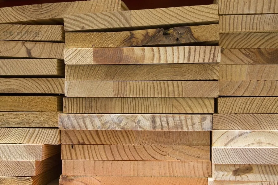 Stacked wood boards showing grain patterns, a material choice for wine cellar racking