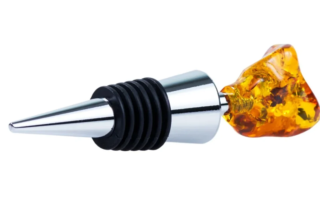 Chrome wine stopper with black rubber rings and an amber glass top for resealing an open bottle