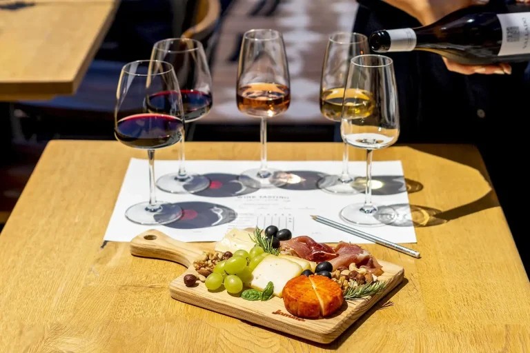 Glasses of Douro wine beside a board of Portuguese cheese, cured ham and grapes